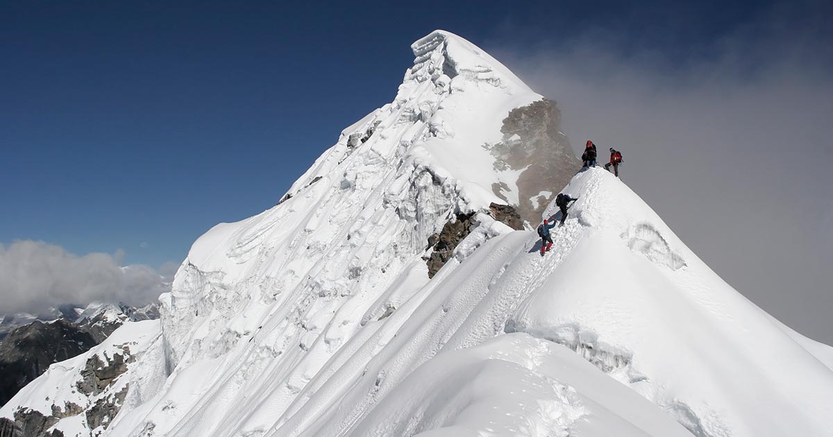 photo of team of people climbing a mountain